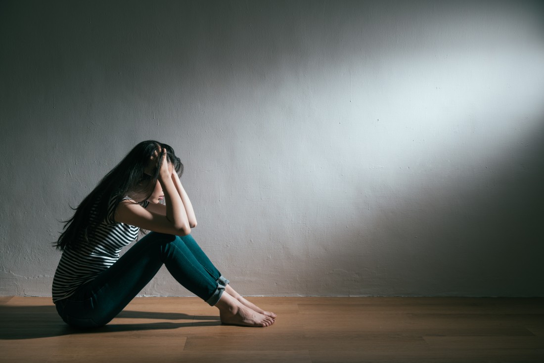Person sitting with head in hands showing distress